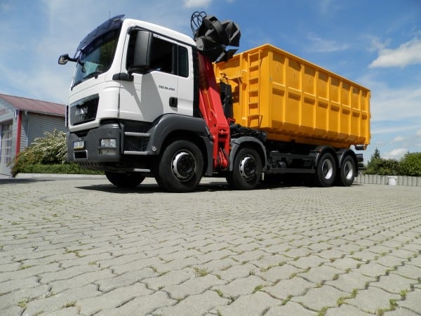 Nákladní vůz MAN se žlutým kontejnerem a hydraulickou rukou