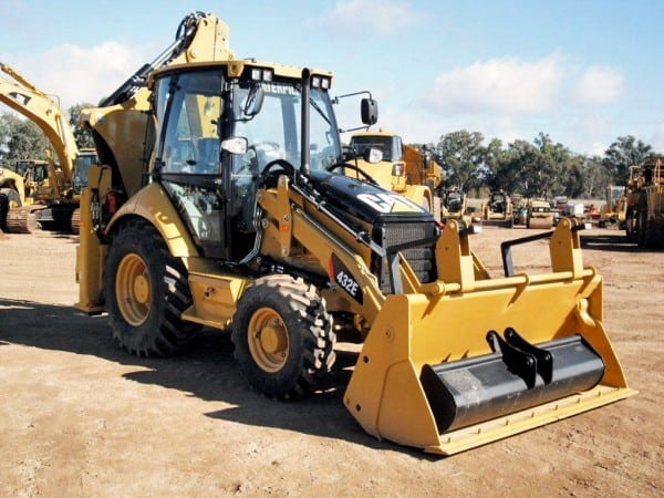 Žlutý rypadlonakladač Caterpillar 432E s přední nakládací lopatou a zadním bagrem